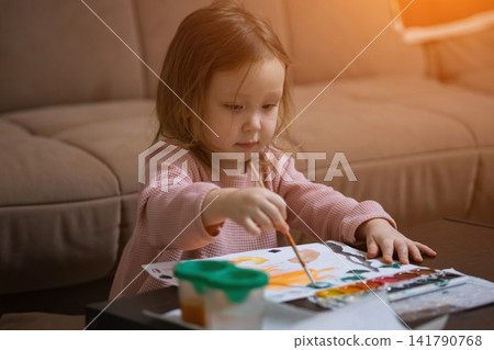Little girl painting with watercolors expressing creativity Little girl painting with watercolors expressing creativity 141790768