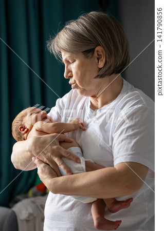Grandmother holding newborn baby symbolizing love and family bond Grandmother holding newborn baby symbolizing love and family bond 141790856