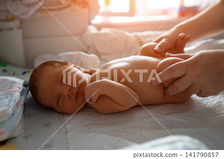 Mother giving newborn baby a gentle massage Mother giving newborn baby a gentle massage 141790857
