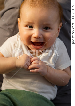 Happy baby laughing and smiling demonstrating childhood joy Happy baby laughing and smiling demonstrating childhood joy 141791153