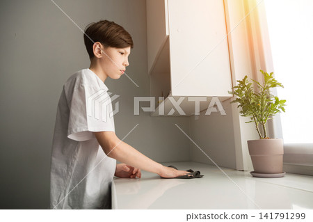 Young boy cleaning desk showing responsibility at home Young boy cleaning desk showing responsibility at home 141791299