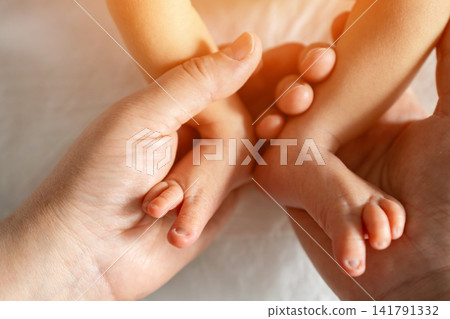 Parents hands holding baby feet showing love protection Parents hands holding baby feet showing love protection 141791332