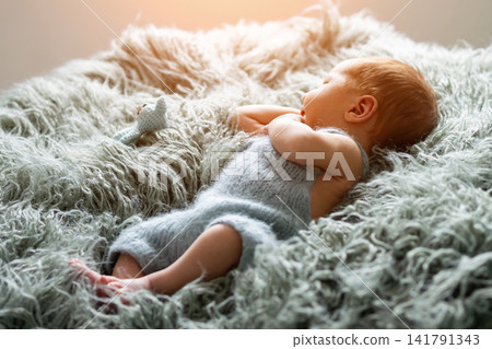 Sleeping newborn baby resting on soft fuzzy blanket Sleeping newborn baby resting on soft fuzzy blanket 141791343