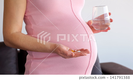 Pregnant woman taking vitamins and supplements for healthy pregnancy Pregnant woman taking vitamins and supplements for healthy pregnancy 141791388