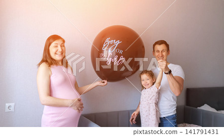 Family anticipating baby's gender reveal at home Family anticipating baby's gender reveal at home 141791431