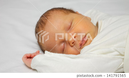 Newborn baby sleeping peacefully on a white blanket Newborn baby sleeping peacefully on a white blanket 141791565