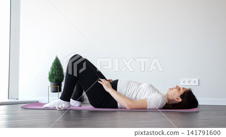 Pregnant woman practicing prenatal yoga for fitness and wellness Pregnant woman practicing prenatal yoga for fitness and wellness 141791600