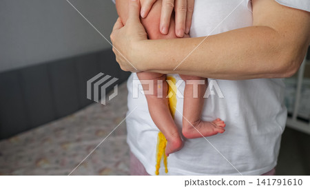 Parent holding newborn with messy diaper blowout Parent holding newborn with messy diaper blowout 141791610