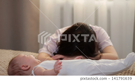 Stressed mother dealing with a fussy crying newborn baby Stressed mother dealing with a fussy crying newborn baby 141791639