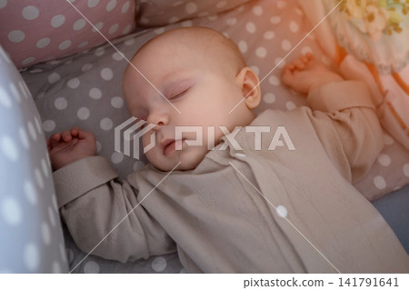 Peaceful baby sleeping in crib with polka dot bedding Peaceful baby sleeping in crib with polka dot bedding 141791641