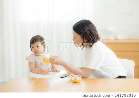 一個一歲女嬰在吃嬰兒食品 一個一歲女嬰在吃嬰兒食品 141792010