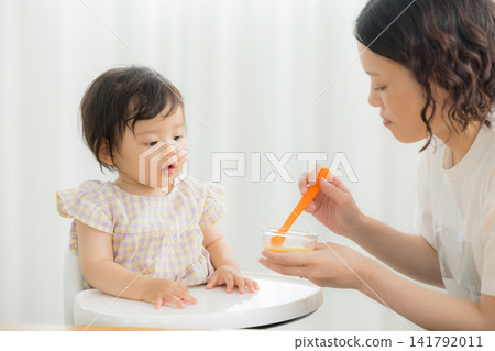 一個一歲女嬰在吃嬰兒食品 一個一歲女嬰在吃嬰兒食品 141792011