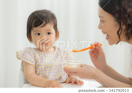 A one-year-old girl eating baby food A one-year-old girl eating baby food 141792013