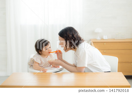 A one-year-old girl eating baby food A one-year-old girl eating baby food 141792018