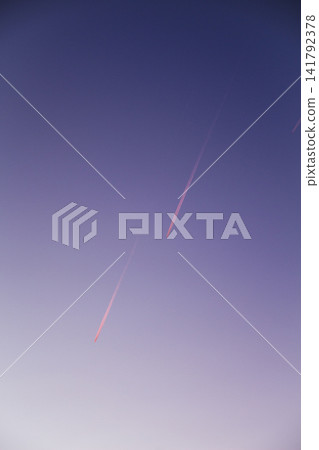 Evening sky with airplane contrails at sunset Evening sky with airplane contrails at sunset 141792378