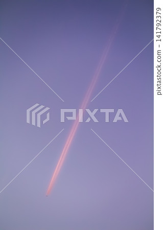Airplane forming contrail in pink sunset sky Airplane forming contrail in pink sunset sky 141792379