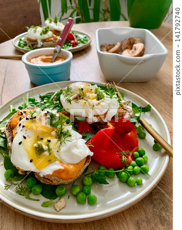 This meal features gluten free bread sandwiches topped with zucchini caviar and poached egg. It includes roasted red peppers and green peas, served with baked pears This meal features gluten free bread sandwiches topped with zucchini caviar and poached egg. It includes roasted red peppers and green peas, served with baked pears 141792740