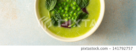 Bright green soup made with broccoli and green peas sits in a bowl. The meal includes liver pate and grissini, suitable for breakfast or lunch, banner Bright green soup made with broccoli and green peas sits in a bowl. The meal includes liver pate and grissini, suitable for breakfast or lunch, banner 141792757