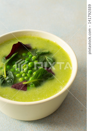 Bright green soup made with broccoli and green peas sits in a bowl. The meal includes liver pate and grissini, suitable for breakfast or lunch Bright green soup made with broccoli and green peas sits in a bowl. The meal includes liver pate and grissini, suitable for breakfast or lunch 141792889