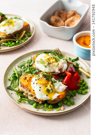 This meal features gluten free bread sandwiches topped with zucchini caviar and poached egg. It includes roasted red peppers and green peas, served with baked pears This meal features gluten free bread sandwiches topped with zucchini caviar and poached egg. It includes roasted red peppers and green peas, served with baked pears 141792948