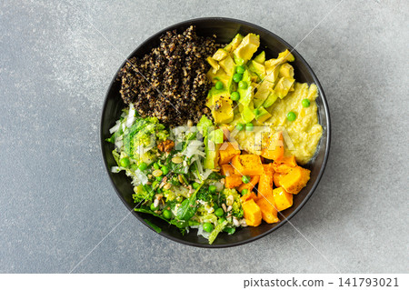A bowl filled with quinoa, roasted pumpkin, hummus, and a salad of fresh avocado is ready to eat. This meal is gluten free and offers a healthy start to the day A bowl filled with quinoa, roasted pumpkin, hummus, and a salad of fresh avocado is ready to eat. This meal is gluten free and offers a healthy start to the day 141793021