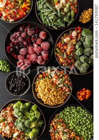 Fresh fruits and vegetables, frozen and placed in plates, on a dark backdrop, symbolizing the process of summer preparations for the colder months ahead Fresh fruits and vegetables, frozen and placed in plates, on a dark backdrop, symbolizing the process of summer preparations for the colder months ahead 141793087