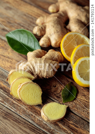 Ginger roots and fresh lemons on an old wooden table. Ginger roots and fresh lemons on an old wooden table. 141793114