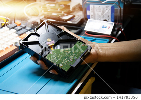 The technician was about to repair the hard drive he was holding. The technician was about to repair the hard drive he was holding. 141793356