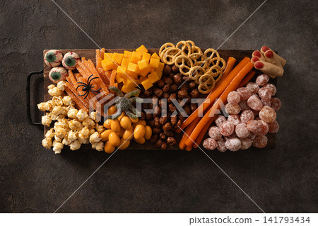 Halloween snack board with popcorn candy and spooky treats above Halloween snack board with popcorn candy and spooky treats above 141793434