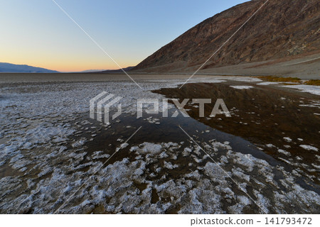 The salt flats of Badwater as dusk approaches, and the still water mirror The salt flats of Badwater as dusk approaches, and the still water mirror 141793472