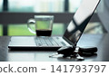 A Contemporary Workspace Featuring a Laptop, Coffee, and Keys, Capturing the Essence of Modern Productivity and Minimalism. 141793797