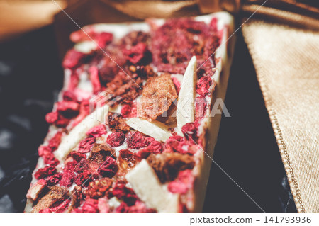 Handmade artisan white chocolate bar with dried raspberries and almond slivers expertly crafted. Handmade artisan white chocolate bar with dried raspberries and almond slivers expertly crafted. 141793936