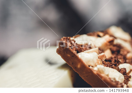 Delicious handmade artisan chocolate with nuts and nougat pieces macro shot Delicious handmade artisan chocolate with nuts and nougat pieces macro shot 141793948