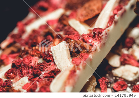 Artisan white chocolate bar with dried berries and nuts close-up detail Artisan white chocolate bar with dried berries and nuts close-up detail 141793949