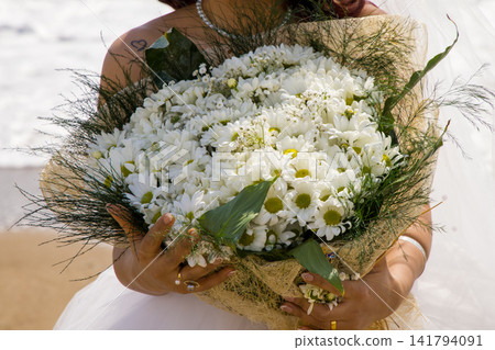 a bride with daisies in her hand a bride with daisies in her hand 141794091
