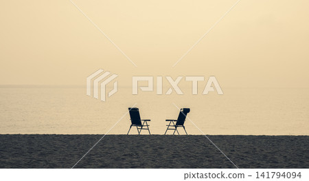 two empty chairs on the beach two empty chairs on the beach 141794094
