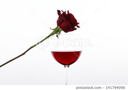Red wine and red rose in front of a white background Red wine and red rose in front of a white background 141794098
