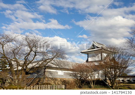 Kanazawa Castle White Turret and Stone Wall with Bare Winter Trees Under Blue Sky Kanazawa Castle White Turret and Stone Wall with Bare Winter Trees Under Blue Sky 141794130