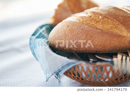 Close-up shot of fresh crusty bread loaf in a basket on table 141794179