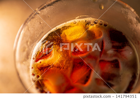 玻璃杯冰塊的特殊照片,杯壁上凝結的水珠,漂浮的冰塊或琥珀色的半透明紋理。 玻璃杯冰塊的特殊照片,杯壁上凝結的水珠,漂浮的冰塊或琥珀色的半透明紋理。 141794351