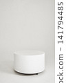 Minimalist white cylindrical pedestal on wheels in empty high key studio 141794485