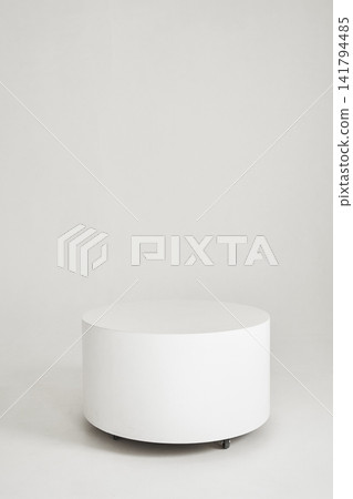 Minimalist white cylindrical pedestal on wheels in empty high key studio Minimalist white cylindrical pedestal on wheels in empty high key studio 141794485