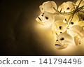 Halloween glowing yellow skull string lights hanging in the dark 141794496