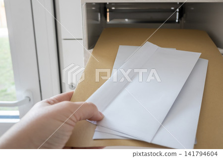Postbox for letters in modern apartment house. The letter in metal white mailbox in lobby of building. 141794604