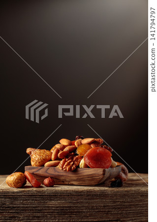 Dried fruits and nuts on a old wooden table. Dried fruits and nuts on a old wooden table. 141794797