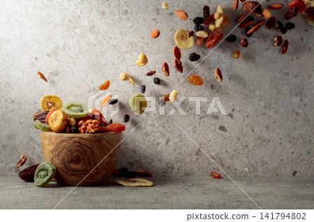 Mix of dried fruits and nuts on a gray stone table. Mix of dried fruits and nuts on a gray stone table. 141794802