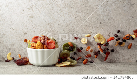 Mix of dried fruits and nuts in a white bowl. Mix of dried fruits and nuts in a white bowl. 141794803