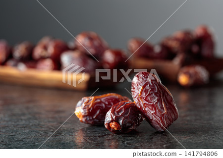 Dried dates fruit on a black table. Dried dates fruit on a black table. 141794806