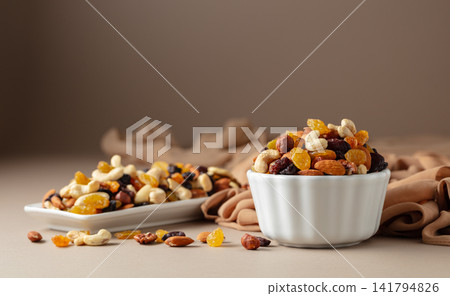 Mix of various nuts and raisins on a beige background. Mix of various nuts and raisins on a beige background. 141794826