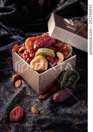 Dried tropical fruits, nuts, and raisins in gift box. Dried tropical fruits, nuts, and raisins in gift box. 141794851